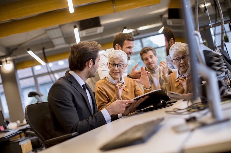 Mitarbeiter:innen verschiedener Generationen im Gespräch im Büro. Die Steuerkanzlei Kettwig berät zur Aktivrente.