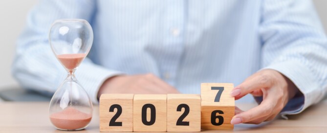 Jahreswechsel von 2026 auf 2027 mmit Holzwürfeln und Sanduhr als Symbol für die kommende Steueränderungen 2027.